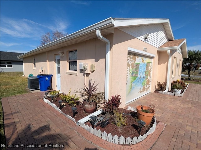 view of side of home with central AC and a patio area