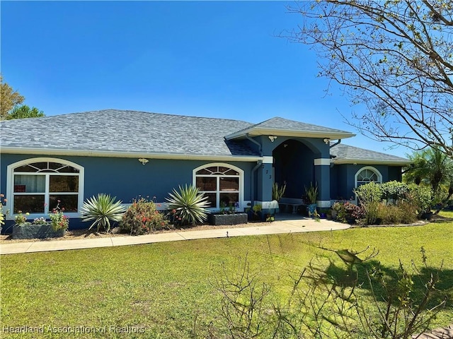 view of front of home featuring a front yard and stucco siding