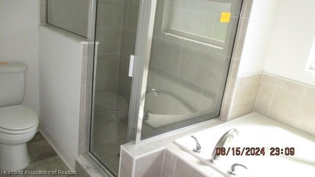 bathroom with shower with separate bathtub and toilet