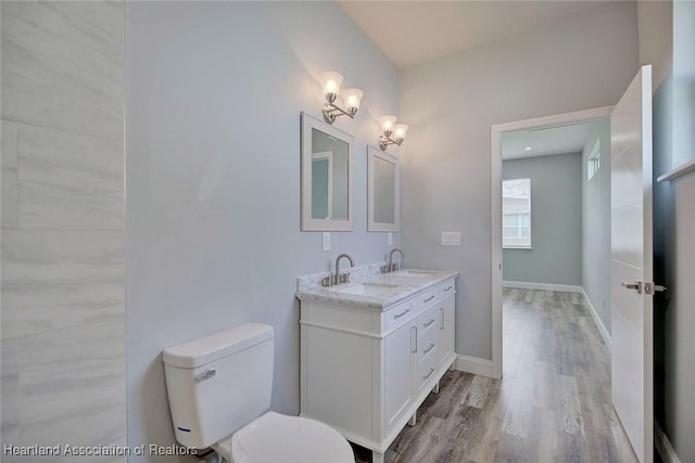 2545 N Odessa Rd, Avon Park, FL 33825 - bathroom featuring wood finished floors, toilet, a chandelier, double vanity, and baseboards