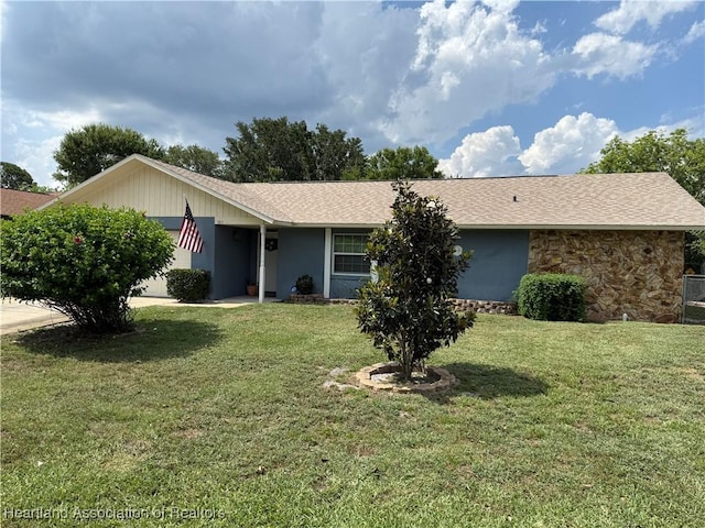 103 Fox Rd, Lake Placid, FL 33852 - view of front of property featuring a front yard, roof with shingles, stone siding, and an attached garage