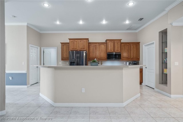 kitchen with a large island with sink, stainless steel appliances, crown molding, and light tile patterned flooring