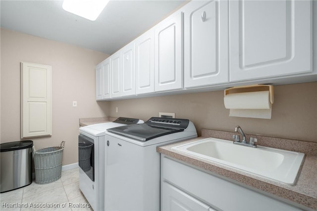 laundry area with washer and clothes dryer, light tile patterned flooring, cabinets, and sink