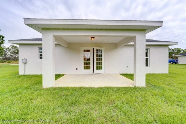 rear view of house featuring a patio and a lawn