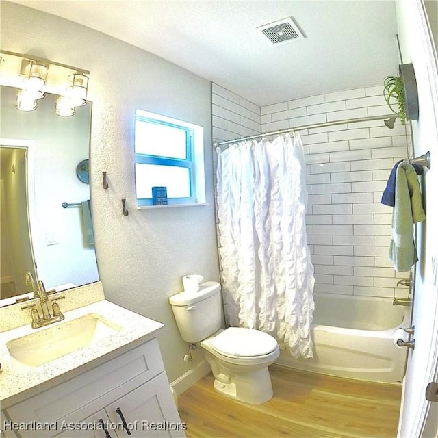 6978 Mexican Hat Dr, Sebring, FL 33872 - bathroom with wood finished floors, vanity, shower / bath combo, and a textured ceiling