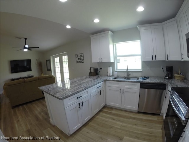 kitchen featuring sink, white cabinets, stainless steel dishwasher, and kitchen peninsula