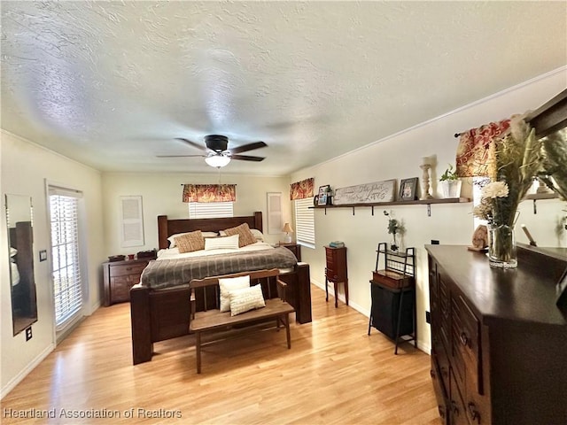 bedroom with light wood-type flooring, ceiling fan, and a textured ceiling