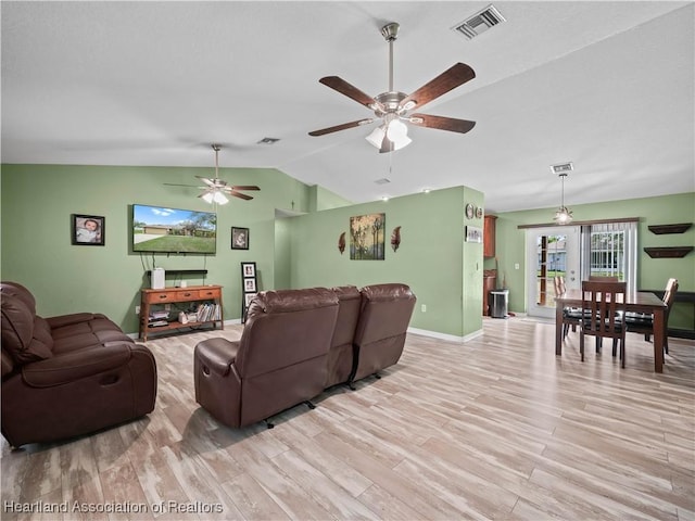 living room with ceiling fan, lofted ceiling, light hardwood / wood-style floors, and french doors