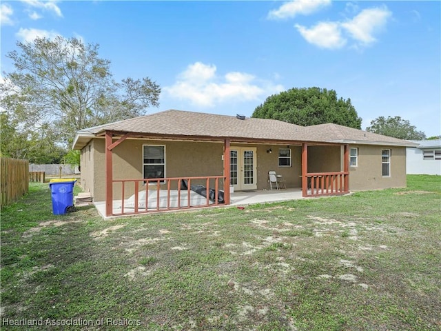 back of property with a lawn and a patio