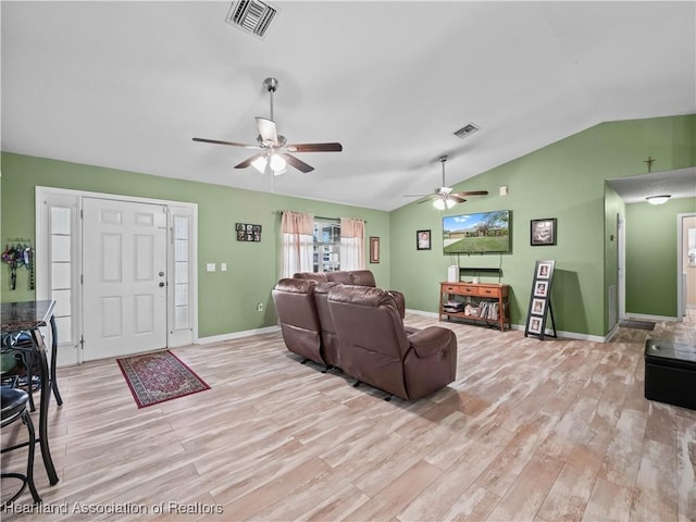 living room with ceiling fan, light hardwood / wood-style flooring, and vaulted ceiling