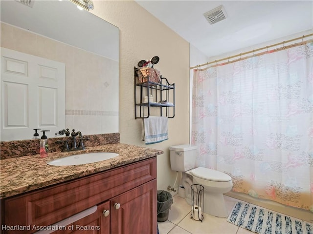 bathroom featuring toilet, vanity, walk in shower, and tile patterned flooring