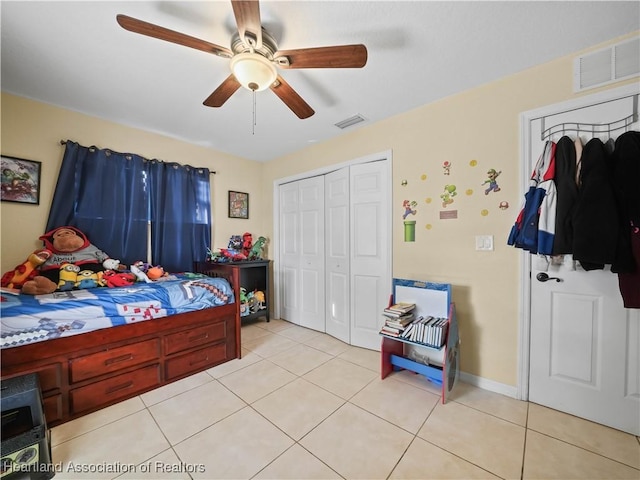 bedroom featuring ceiling fan, light tile patterned floors, and a closet