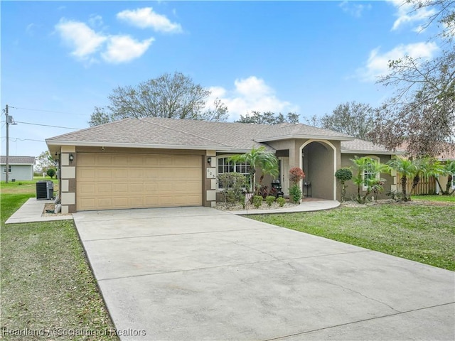 ranch-style house featuring a garage, a front lawn, and central AC unit