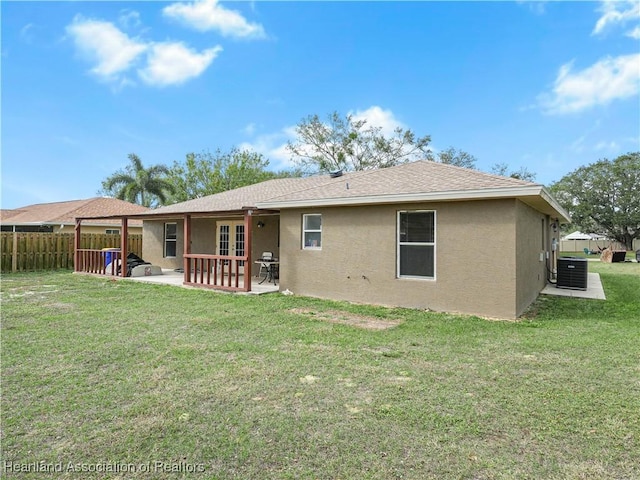 rear view of property with a patio area, cooling unit, and a lawn