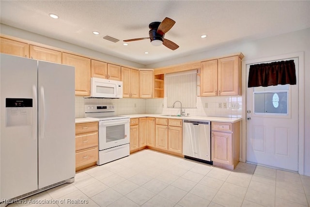 kitchen with light brown cabinetry, white appliances, ceiling fan, and sink