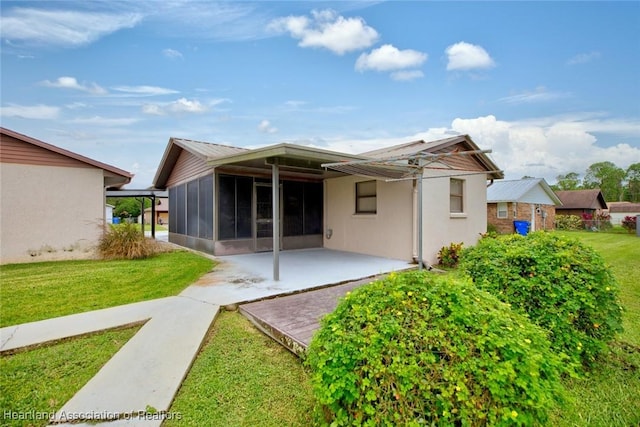 back of house with a sunroom and a yard