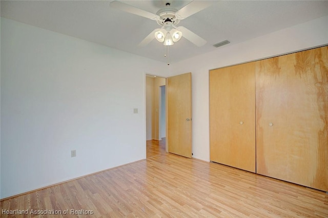 unfurnished bedroom with ceiling fan, light hardwood / wood-style flooring, and a closet