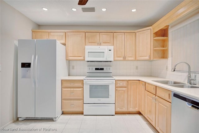 kitchen featuring sink, light brown cabinets, backsplash, white appliances, and light tile patterned floors