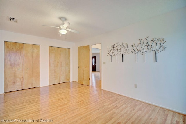 spare room with ceiling fan and light wood-type flooring