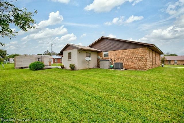 rear view of house featuring a yard and cooling unit