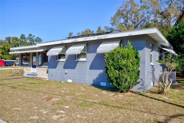 view of side of property featuring cooling unit and a lawn