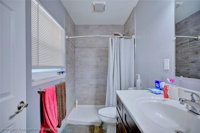 bathroom featuring vanity, toilet, and walk in shower