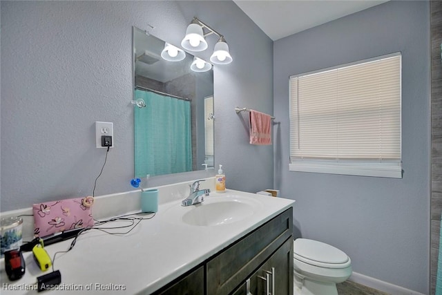 bathroom featuring vanity, toilet, and walk in shower