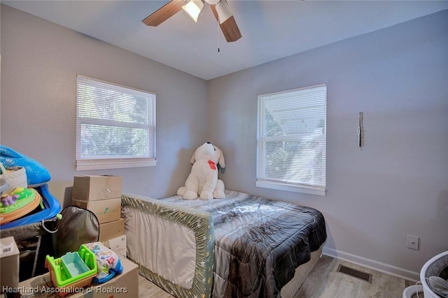 bedroom with ceiling fan and multiple windows