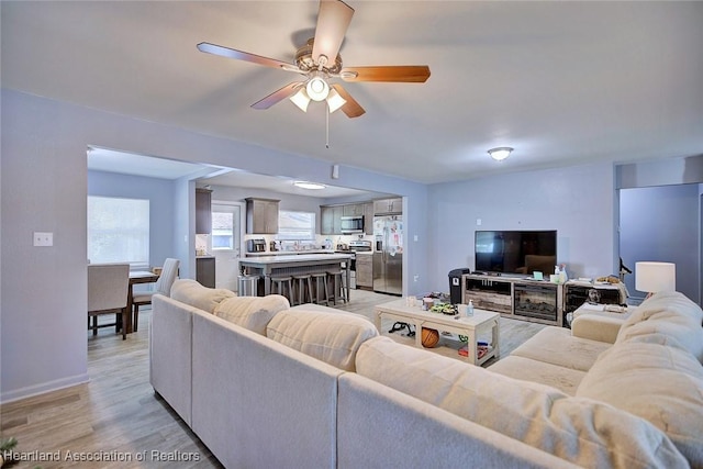 living room featuring ceiling fan and light hardwood / wood-style floors