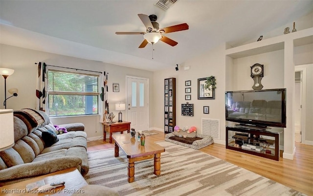 living room with hardwood / wood-style flooring, vaulted ceiling, and ceiling fan