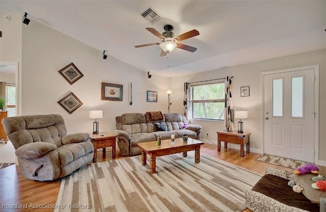 living room with ceiling fan, light hardwood / wood-style floors, and lofted ceiling