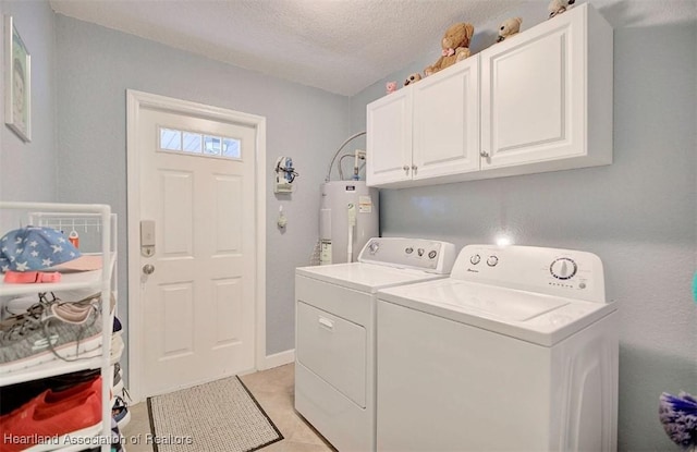 laundry room with cabinets, a textured ceiling, water heater, light tile patterned floors, and separate washer and dryer