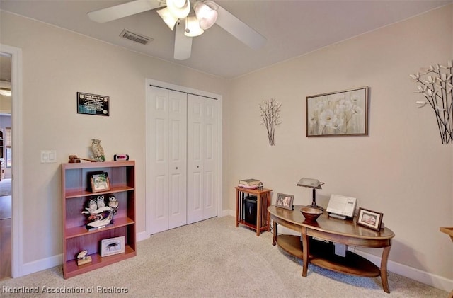 interior space with light carpet and ceiling fan