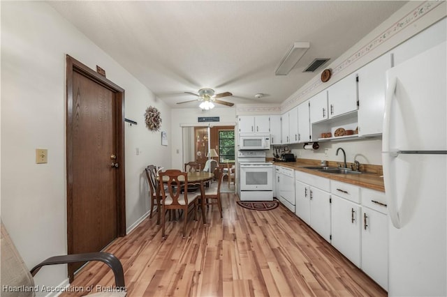 kitchen with white appliances, white cabinetry, sink, ceiling fan, and light hardwood / wood-style flooring