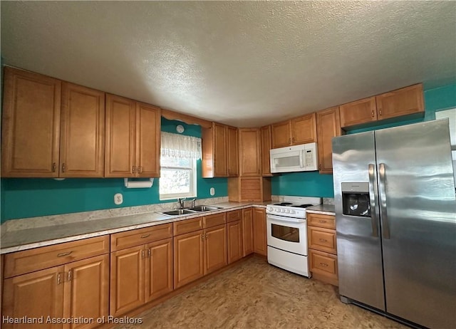 kitchen with white appliances, sink, and a textured ceiling