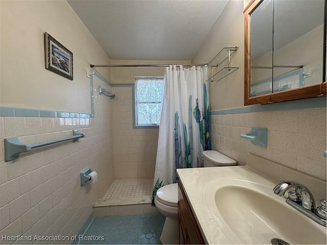 bathroom featuring tile patterned floors, toilet, a shower with curtain, tile walls, and vanity