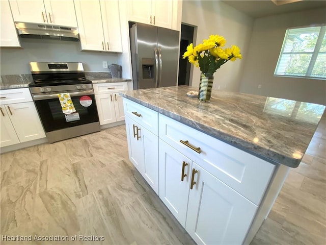 kitchen featuring stone countertops, a kitchen island, white cabinetry, and stainless steel appliances