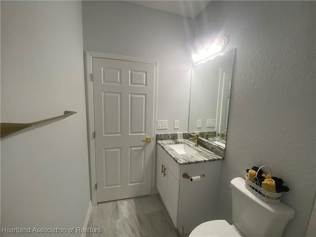 bathroom featuring hardwood / wood-style floors, vanity, and toilet