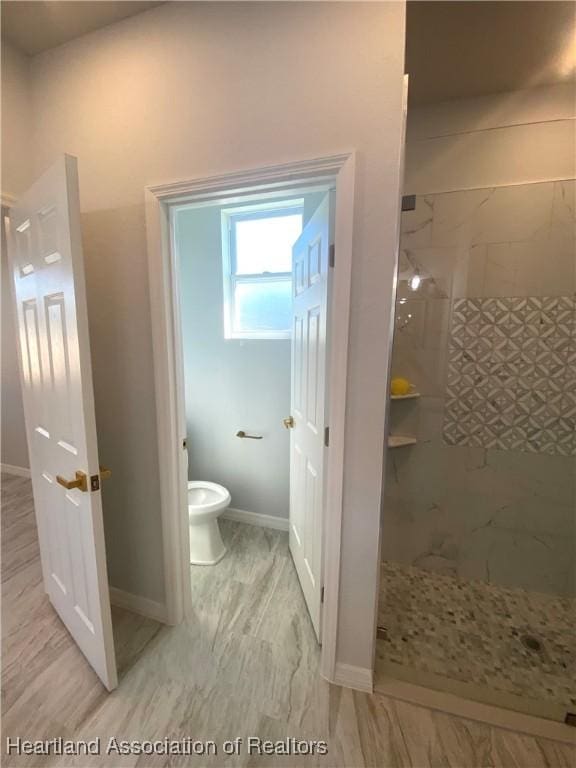 bathroom with toilet and tiled shower