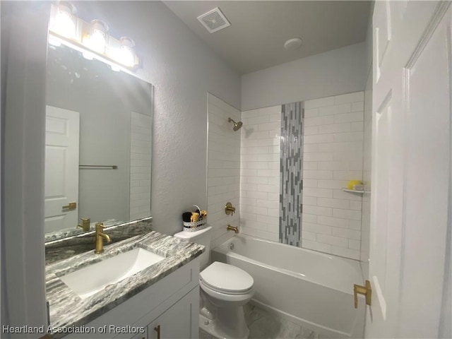 full bathroom with vanity, tiled shower / bath combo, and toilet