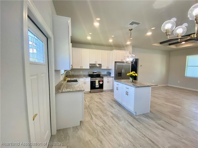 kitchen with sink, stainless steel appliances, a kitchen island, decorative light fixtures, and white cabinets