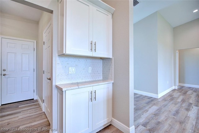 hallway featuring baseboards and light wood finished floors