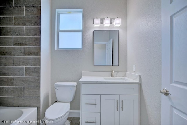 full bathroom featuring vanity, a textured wall, and toilet
