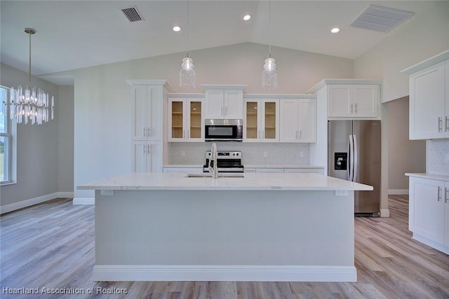 kitchen featuring appliances with stainless steel finishes, backsplash, vaulted ceiling, and visible vents