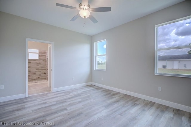 unfurnished room featuring a ceiling fan, baseboards, and light wood-style floors