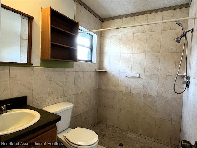 full bathroom with tile walls, toilet, a stall shower, vanity, and a textured ceiling