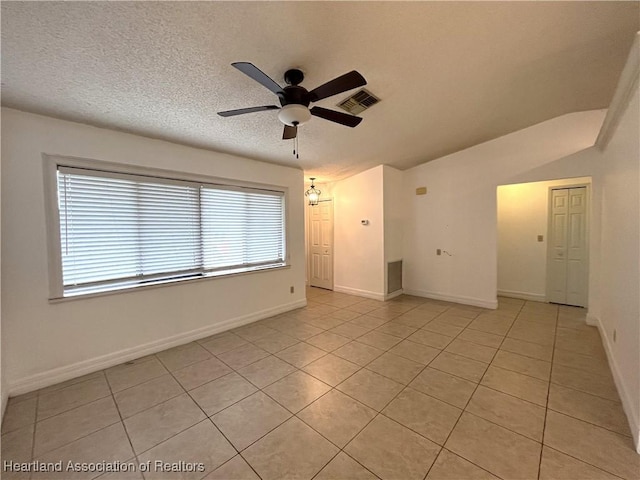 spare room featuring ceiling fan, visible vents, a textured ceiling, and light tile patterned flooring