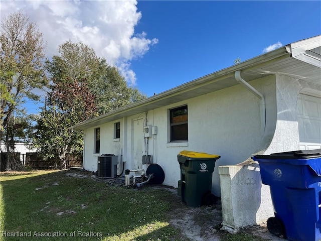 view of side of property with cooling unit and a yard