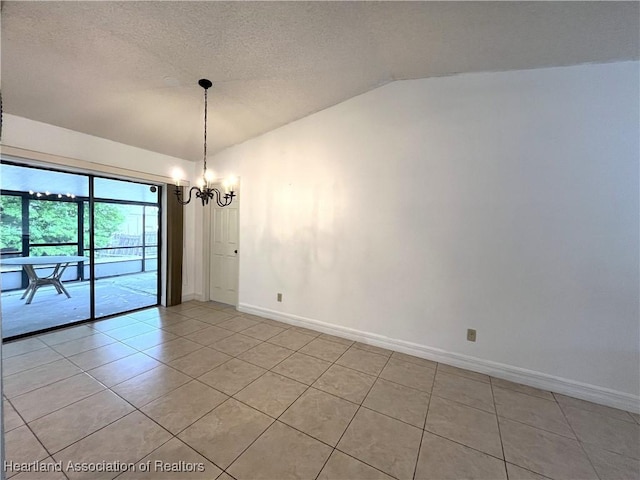 empty room with lofted ceiling, light tile patterned floors, a textured ceiling, a chandelier, and baseboards