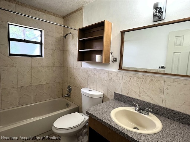 full bath featuring toilet, shower / tub combination, a textured ceiling, vanity, and tile walls